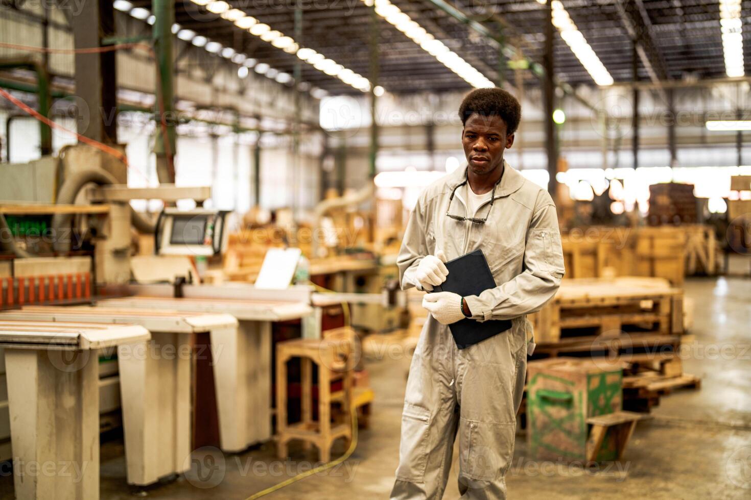 African man workers engineering standing with confidence with working suite dress and hand glove in front machine. Concept of smart industry worker operating. Wood factory produce wood palate. photo