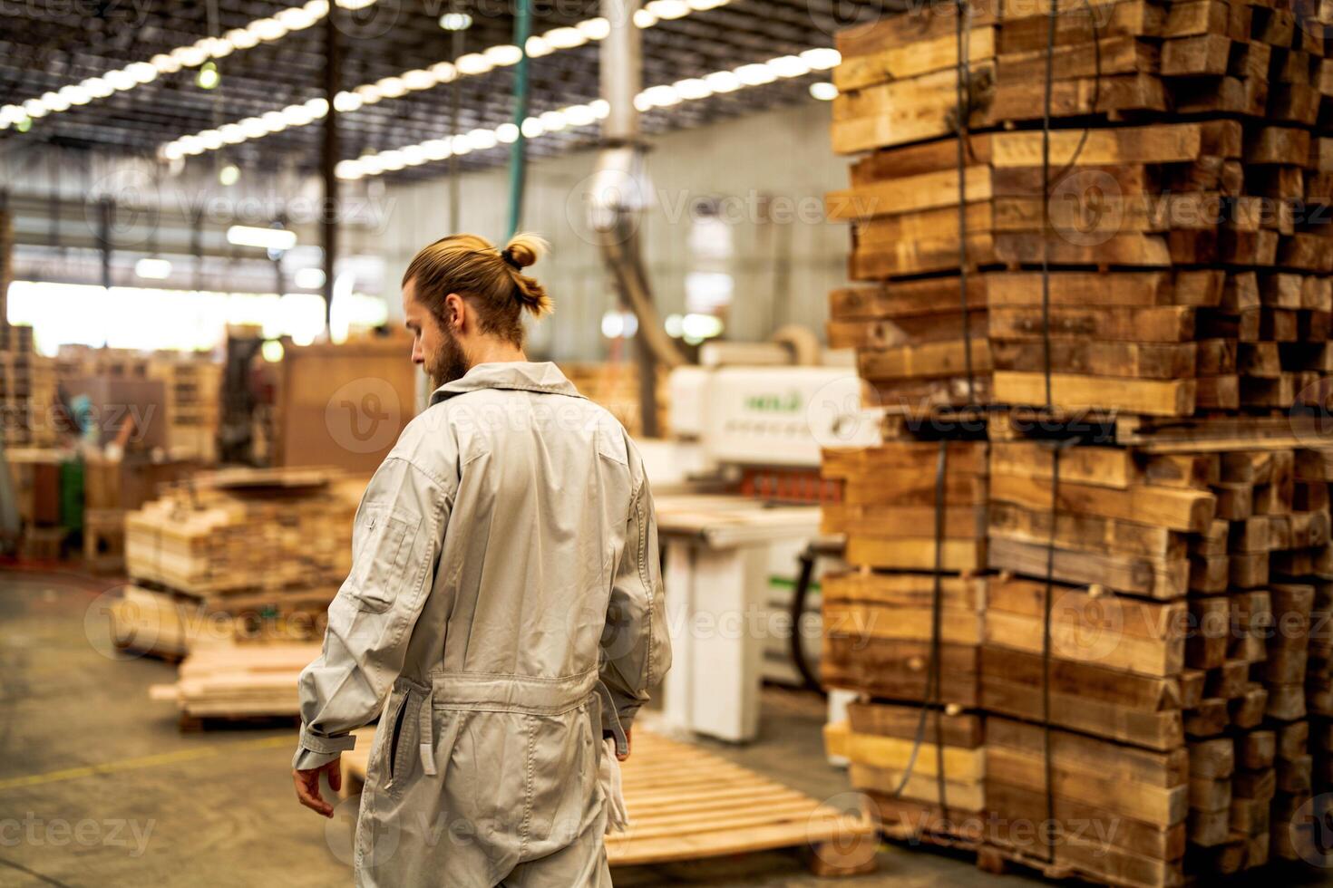 man workers engineering standing with confidence with working suite dress and hand glove in front machine. Concept of smart industry worker operating. Wood factory produce wood palate. photo