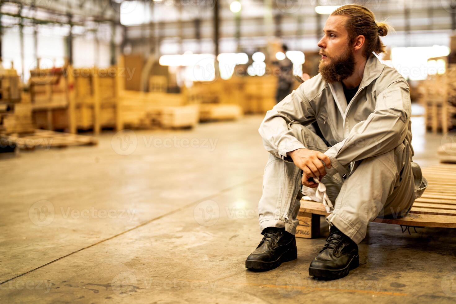 man workers engineering sitting with confidence with working suite dress and hand glove in front machine. Concept of smart industry worker operating. Wood factory produce wood palate. photo
