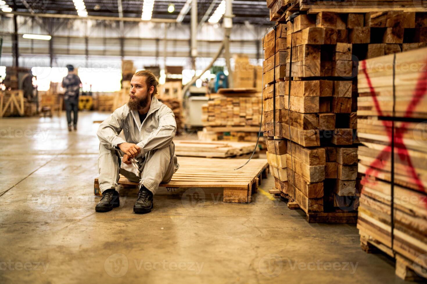 man workers engineering sitting with confidence with working suite dress and hand glove in front machine. Concept of smart industry worker operating. Wood factory produce wood palate. photo