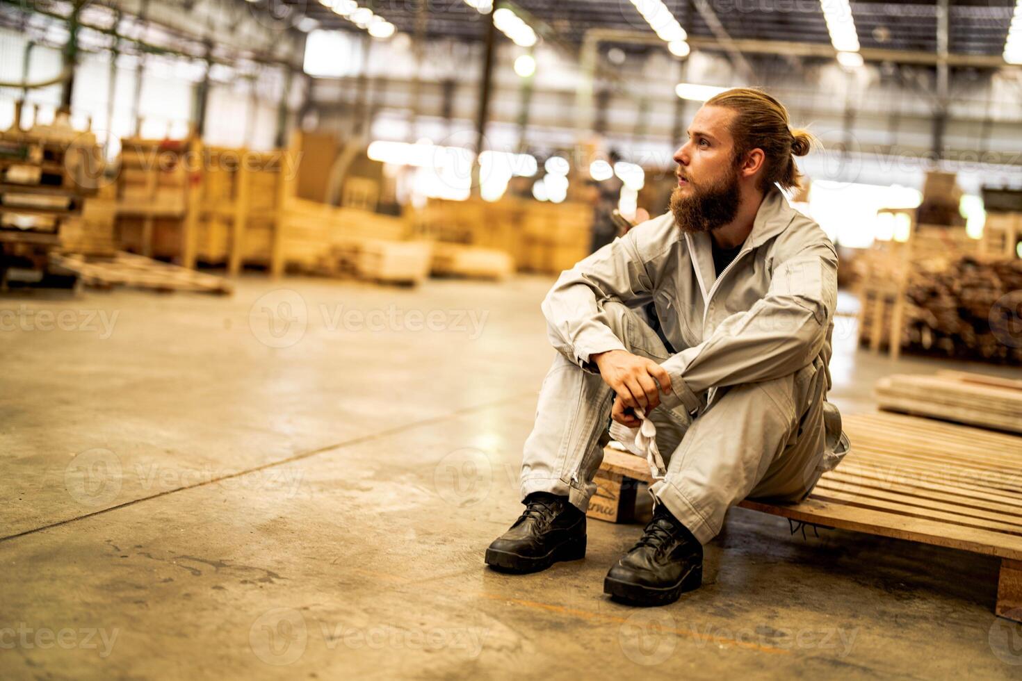 man workers engineering sitting with confidence with working suite dress and hand glove in front machine. Concept of smart industry worker operating. Wood factory produce wood palate. photo