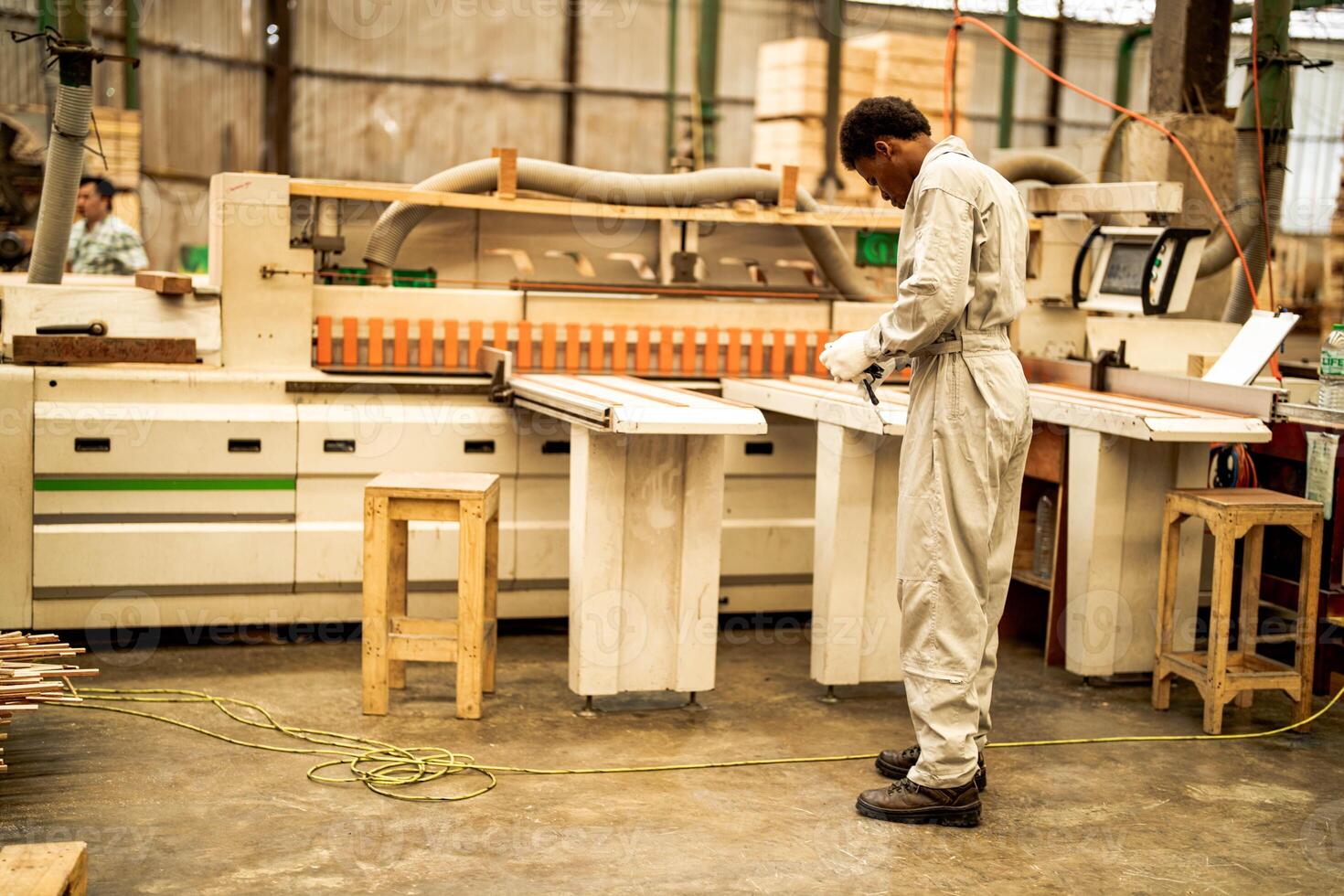 African man workers engineering standing with confidence with working suite dress and hand glove in front machine. Concept of smart industry worker operating. Wood factory produce wood palate. photo