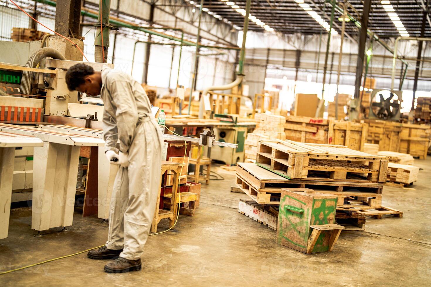African man workers engineering standing with confidence with working suite dress and hand glove in front machine. Concept of smart industry worker operating. Wood factory produce wood palate. photo