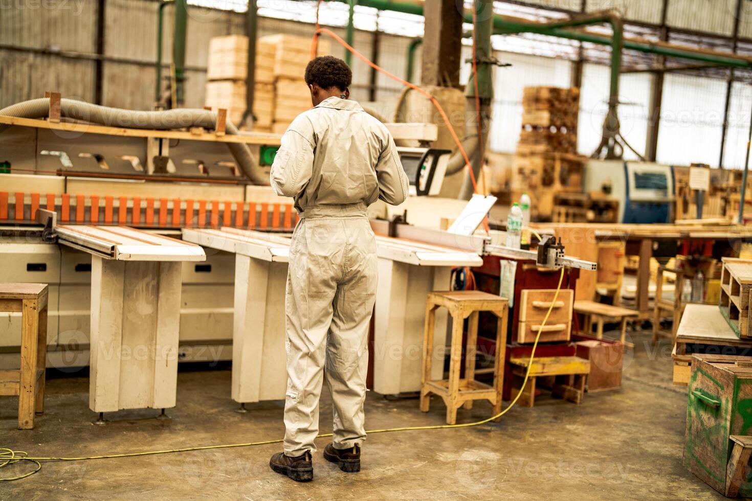 African man workers engineering standing with confidence with working suite dress and hand glove in front machine. Concept of smart industry worker operating. Wood factory produce wood palate. photo
