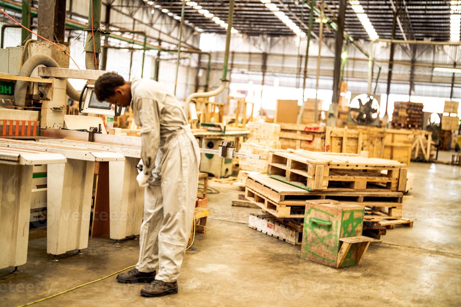 africano hombre trabajadores Ingenieria en pie con confianza con trabajando suite vestir y mano guante en frente máquina. concepto de inteligente industria trabajador operando. madera fábrica Produce madera paladar. foto