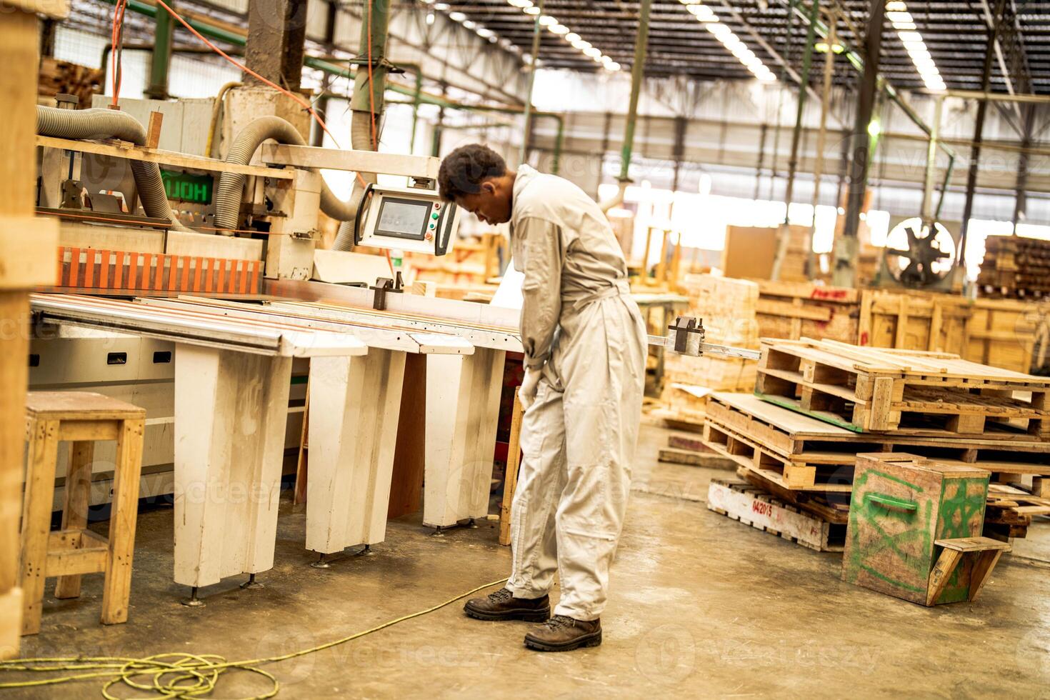 africano hombre trabajadores Ingenieria en pie con confianza con trabajando suite vestir y mano guante en frente máquina. concepto de inteligente industria trabajador operando. madera fábrica Produce madera paladar. foto