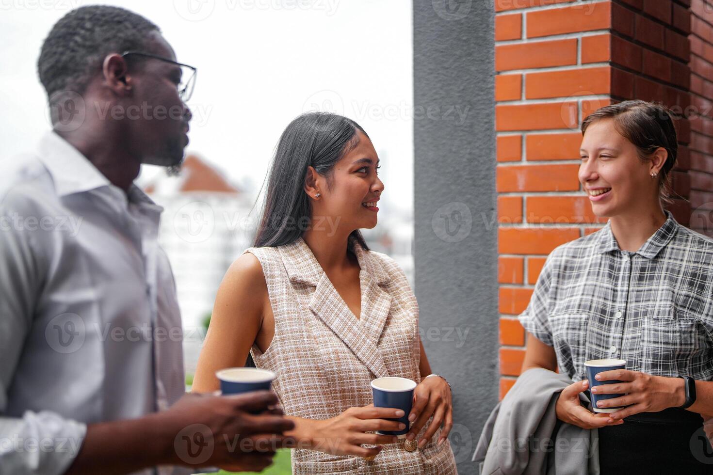 equipo de negocio personas inteligente hombre y mujer estar a al aire libre terraza edificio y hablar juntos con desayuno comida y café en el mano en bueno sensación con ciudad espacio edificio. negocio Mañana. foto