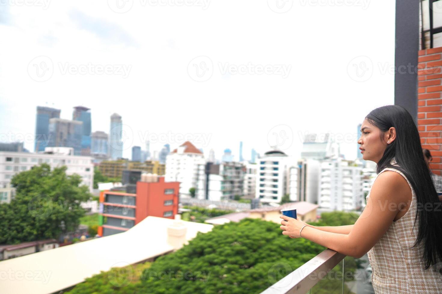 africano negocio inteligente mujer soportes a al aire libre terraza edificio. personas con en mano en bueno sensación con ciudad espacio edificio. relajante de personas negocio Mañana. foto