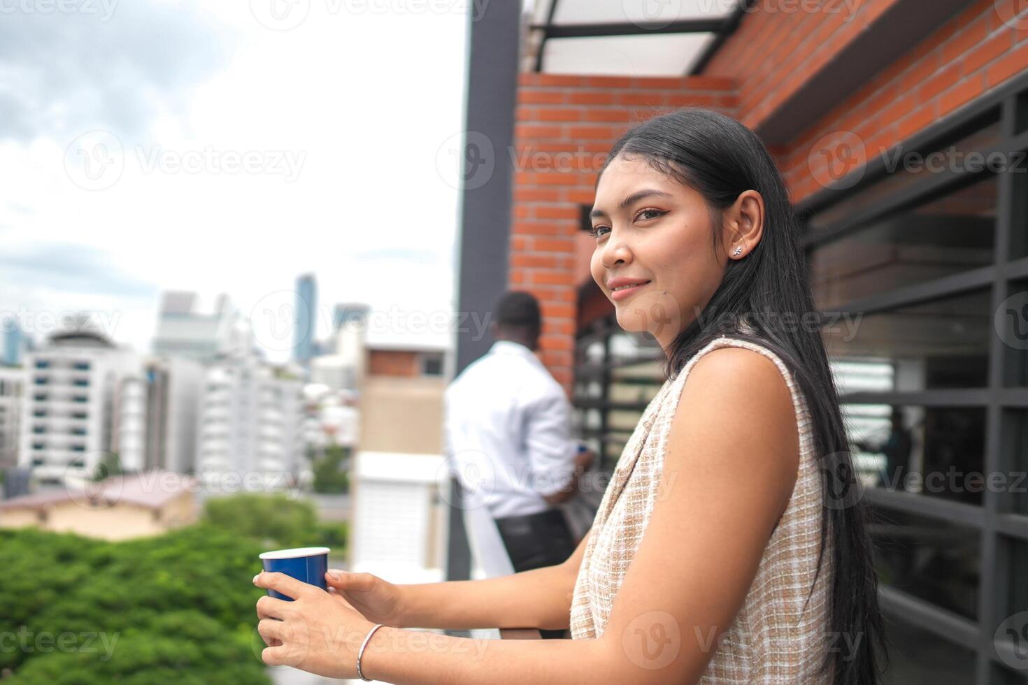 African business smart woman stands at outdoor terrace building. people with on hand in good feeling with city space building. relaxing of people business morning. photo