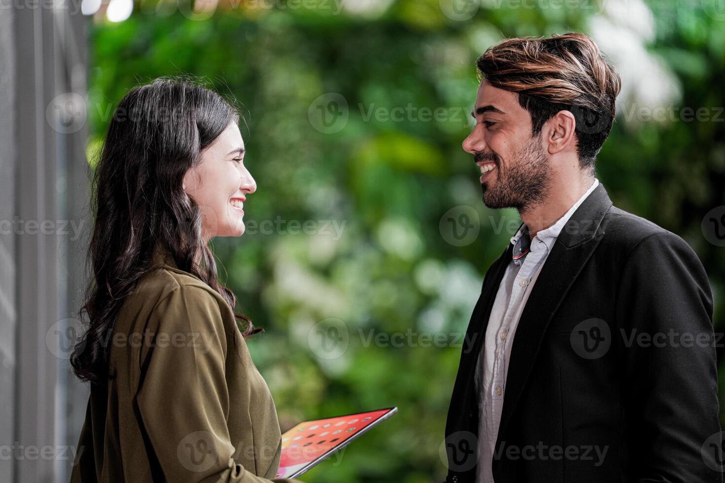 empresario y casual mujer de negocios sacudida manos al aire libre. dos joven multicultural compañeros de trabajo acuerdo para éxito. antecedentes de verde pared naturaleza arboles foto