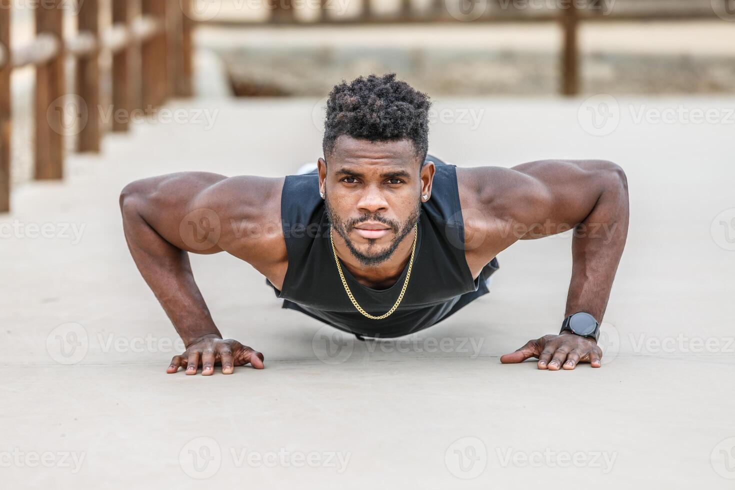 Motivated black sportsman doing push ups in park photo