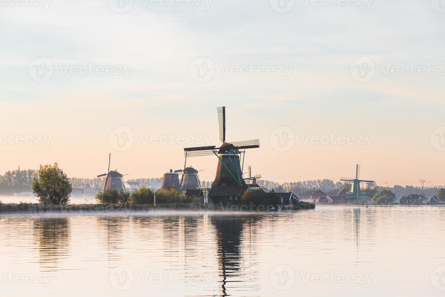 Popular tourist spot Zaanse Schans is near Amsterdam in the west of the Netherlands. Historical, realistic windmills during sunrise. Holland's landmark photo