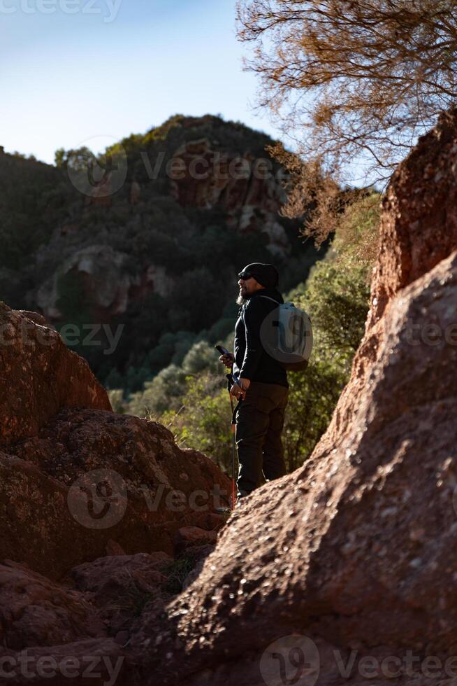 de edad mediana hombre contempla el paisajes de el garrafa natural parque mientras caminando a lo largo el caminos de un montaña. foto