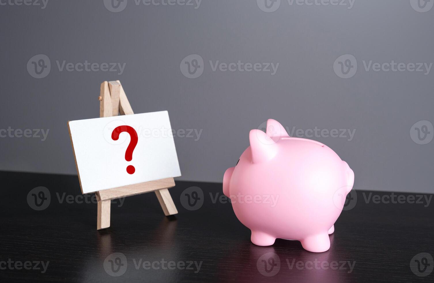 Piggy bank looking at the question mark on the stand. Financial literacy. The best ways to save and invest. Financial forecast, plans for the future and new trends. photo
