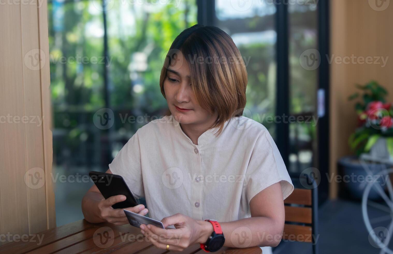 Women sitting on chair at outdoor the cafe holding credit cards and using smartphone to shopping online payments,Internet banking applications and e-commerce photo