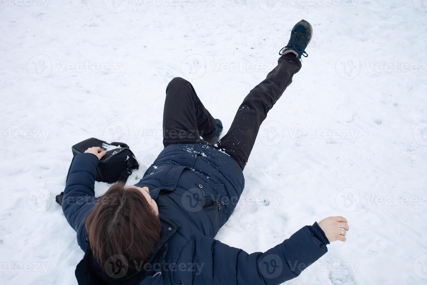 A man falls in the snow. The man slipped and was injured. Falling on ice. Winter. Fracture, bruise, dislocation. photo