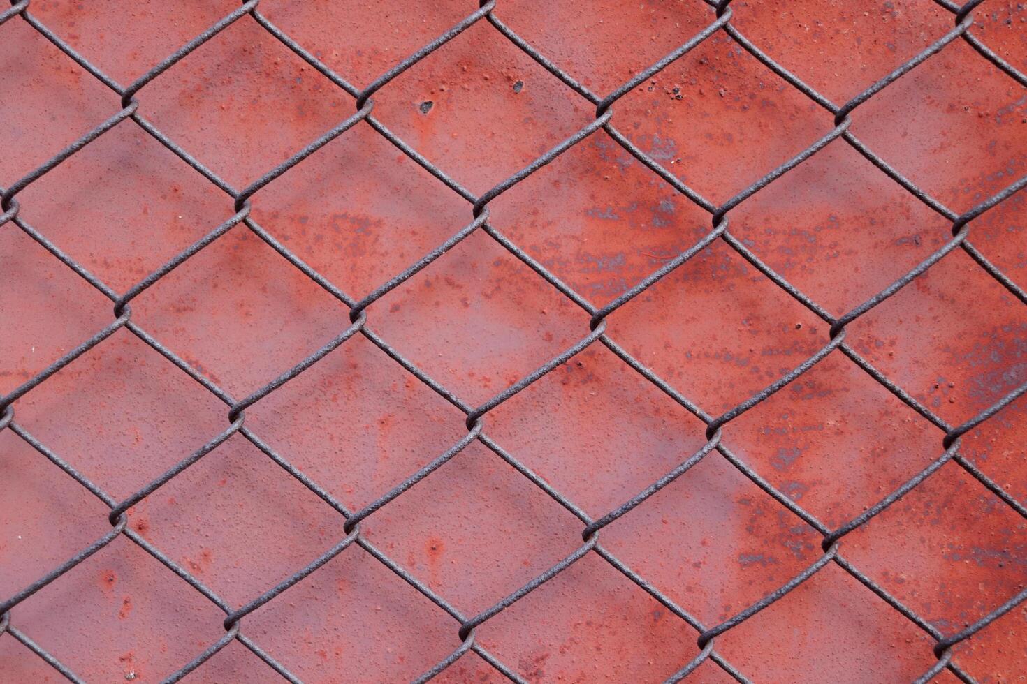 Chain link fencing mesh or wire gauze and red painted metal with rusty on surface background. photo