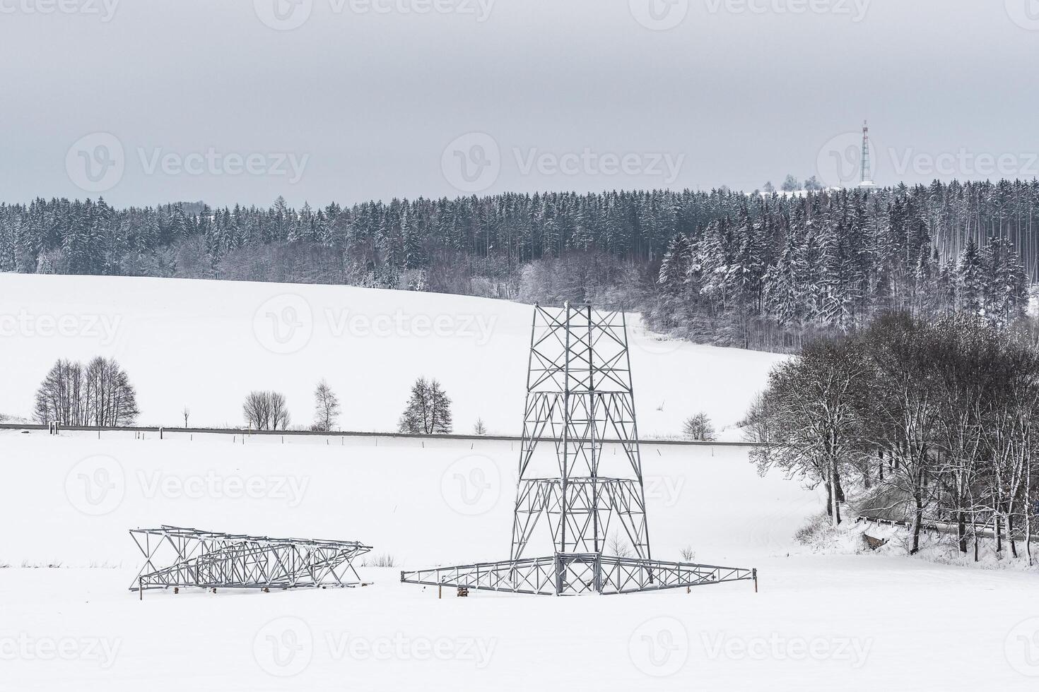 Construction of high voltage pylons in winter. Assembled power transmission line supports, ready for installation. photo