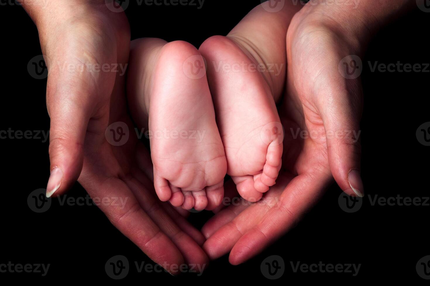 Little baby feet in mother's hands photo