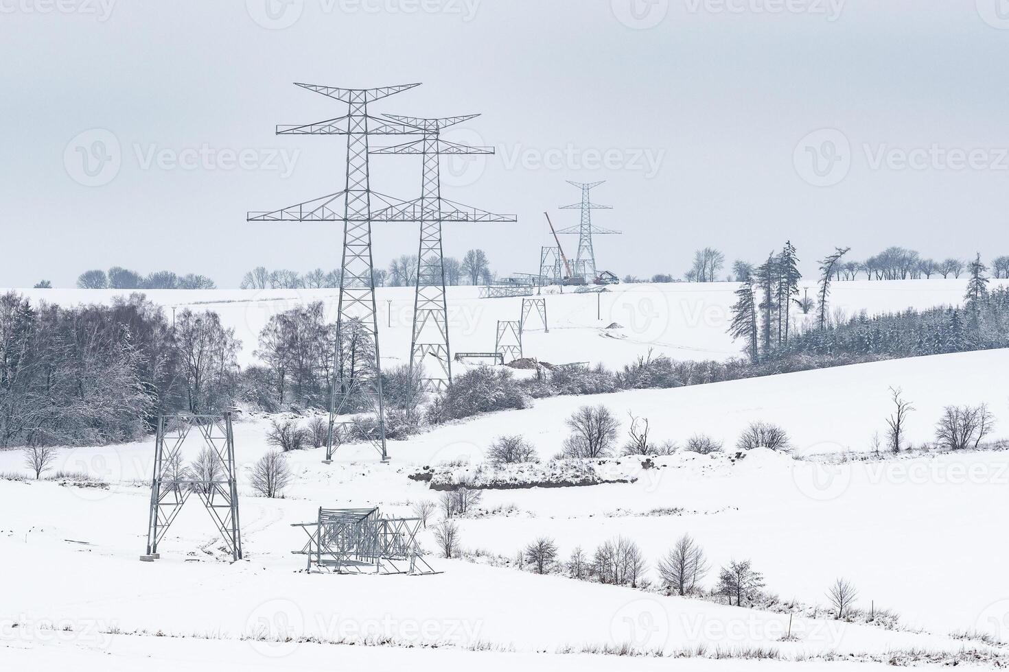 Construction of high voltage pylons in winter. Assembled power transmission line supports, ready for installation. photo