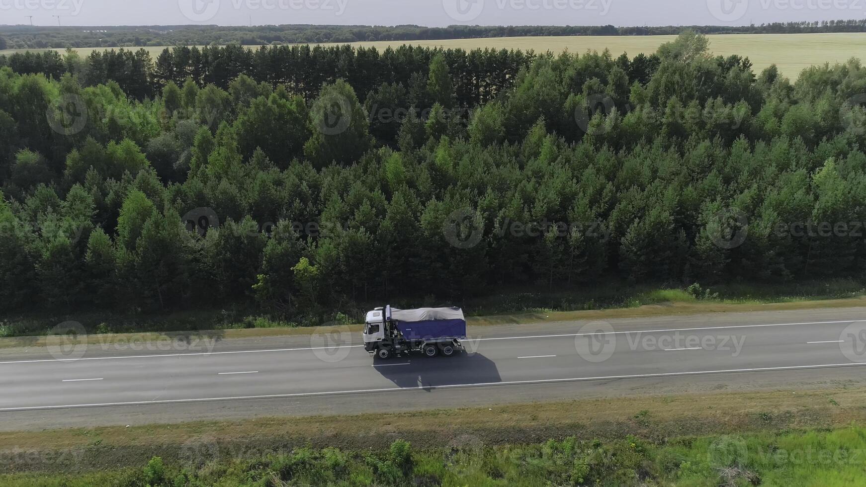 Dump truck driving on highway. Scene. Top view of dump truck on highway in summer. Truckers and dump trucks on country road photo