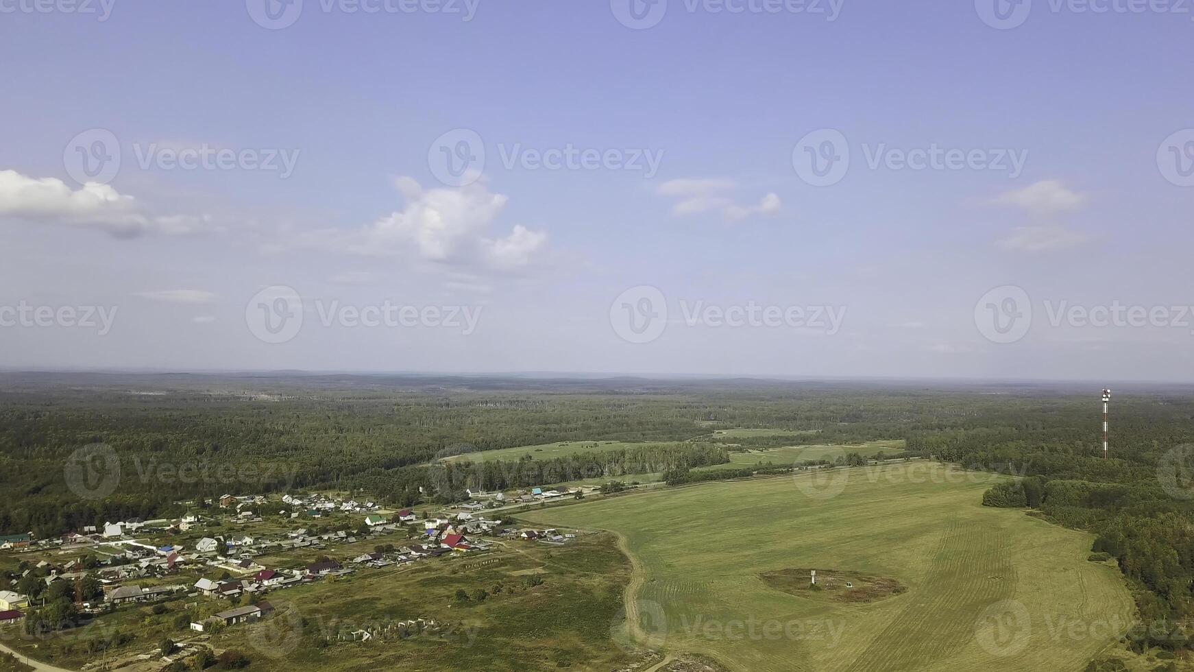 Aerial view of outback and typical old village in forest. Stock footage. Top view of houses among green trees near the meadow, summer landscape. photo