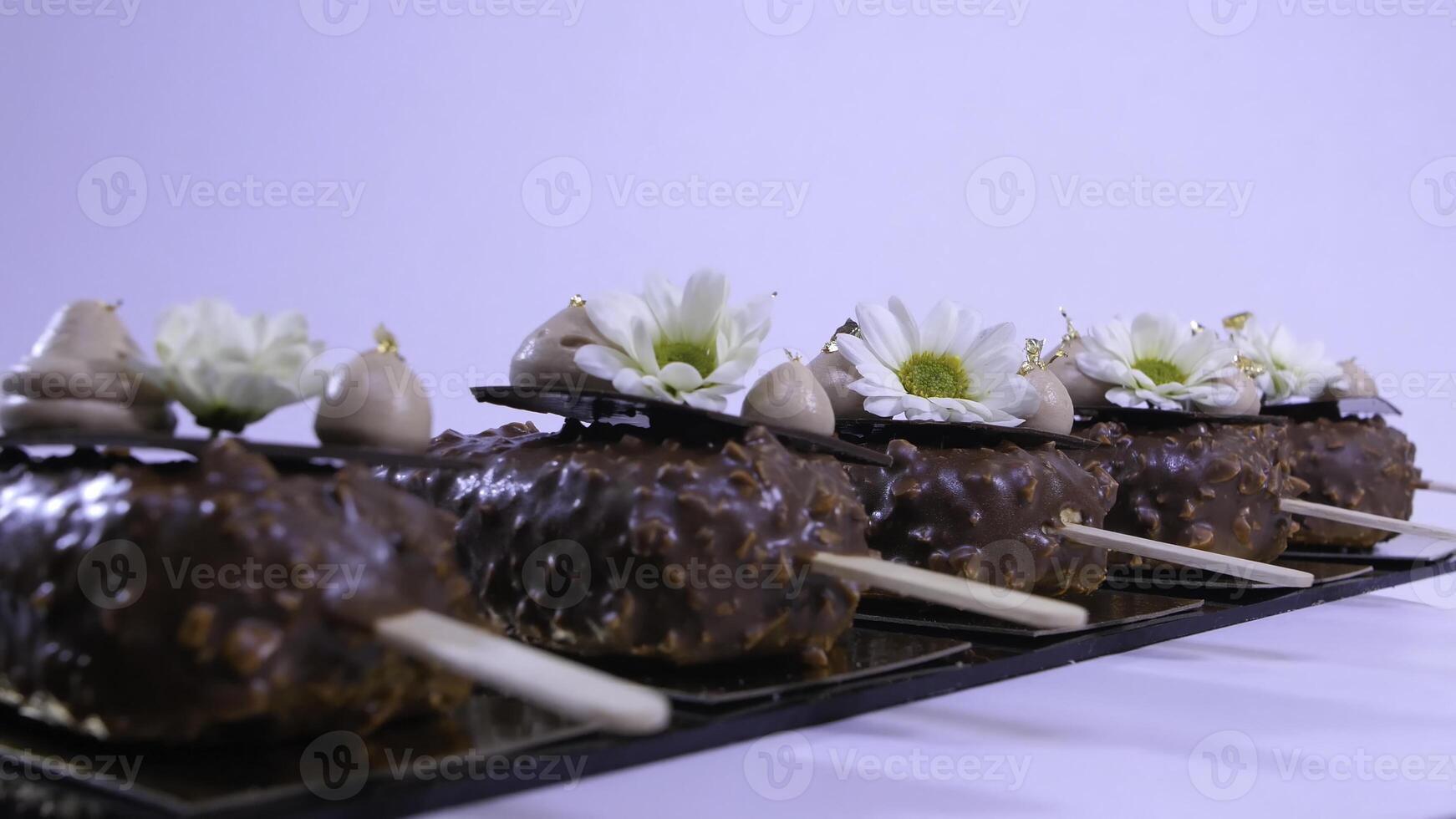 Flowers and cream on the ice cream closeup. Chocolate ice cream on a stick. Chocolate ice cream on a stick decorated with flowers photo