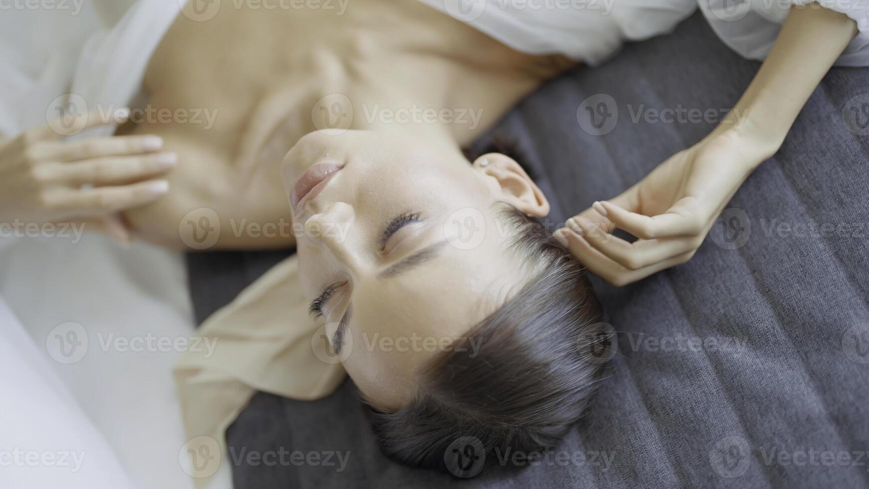 Beautiful woman in white dress is lying on bed. Action. Close-up of beautiful and elegant woman resting on bed. Young elegant woman basking on bed photo