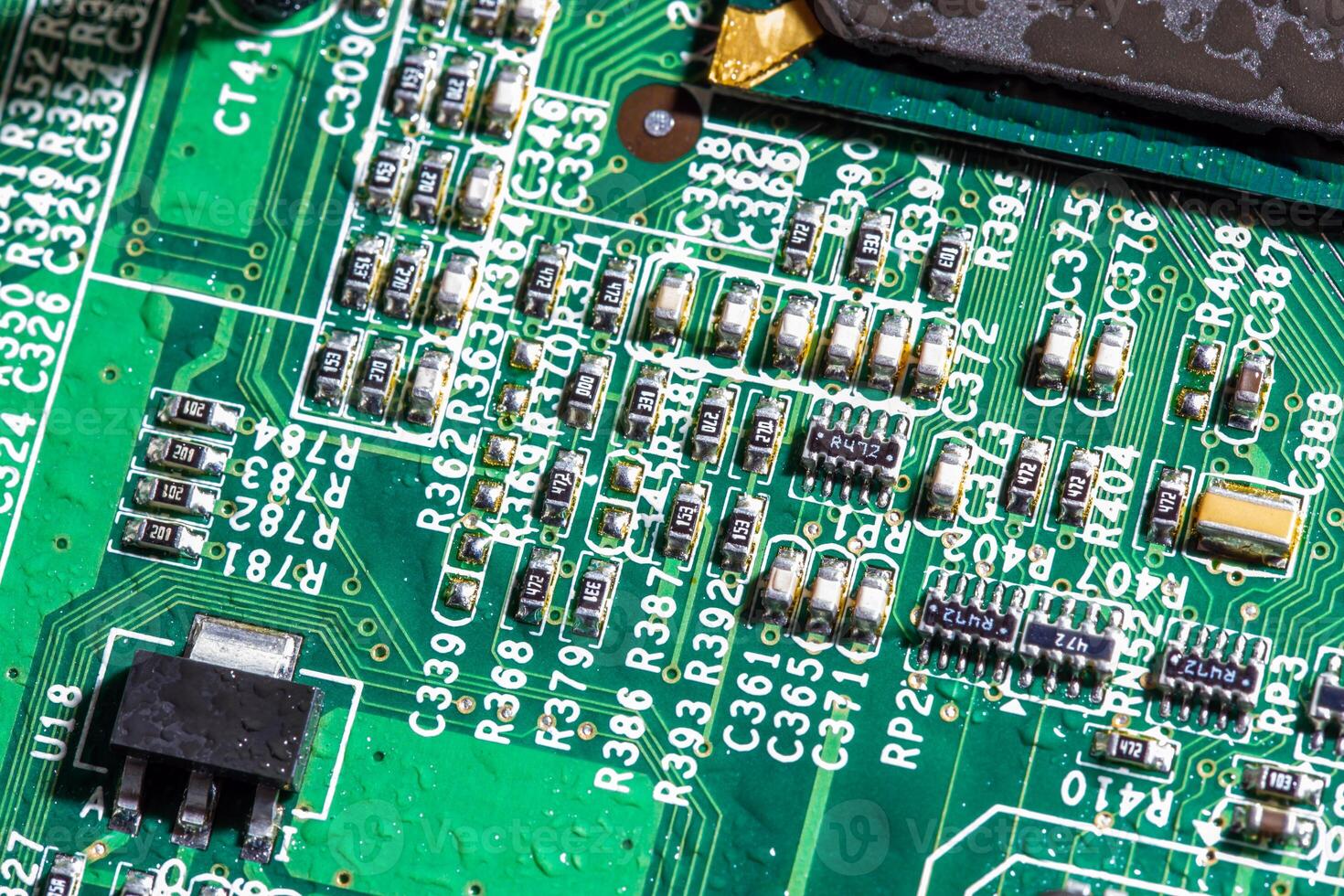 wet digital circuit board with microprocessors and components, closeup full-frame macro background photo