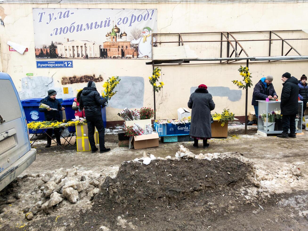 people selling mimosas on a dirty spring street in Tula, Russia photo