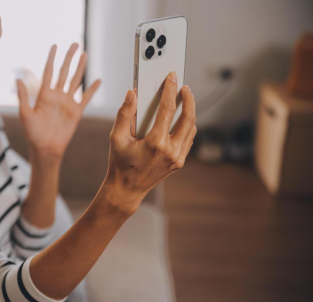 felicidad empresaria hermosa mujer joven asiática de negocios usa un teléfono móvil de uso informal para comprar en línea disfrutar con las redes sociales y una computadora portátil en casa. inicio de una pequeña empresa. banca en línea foto