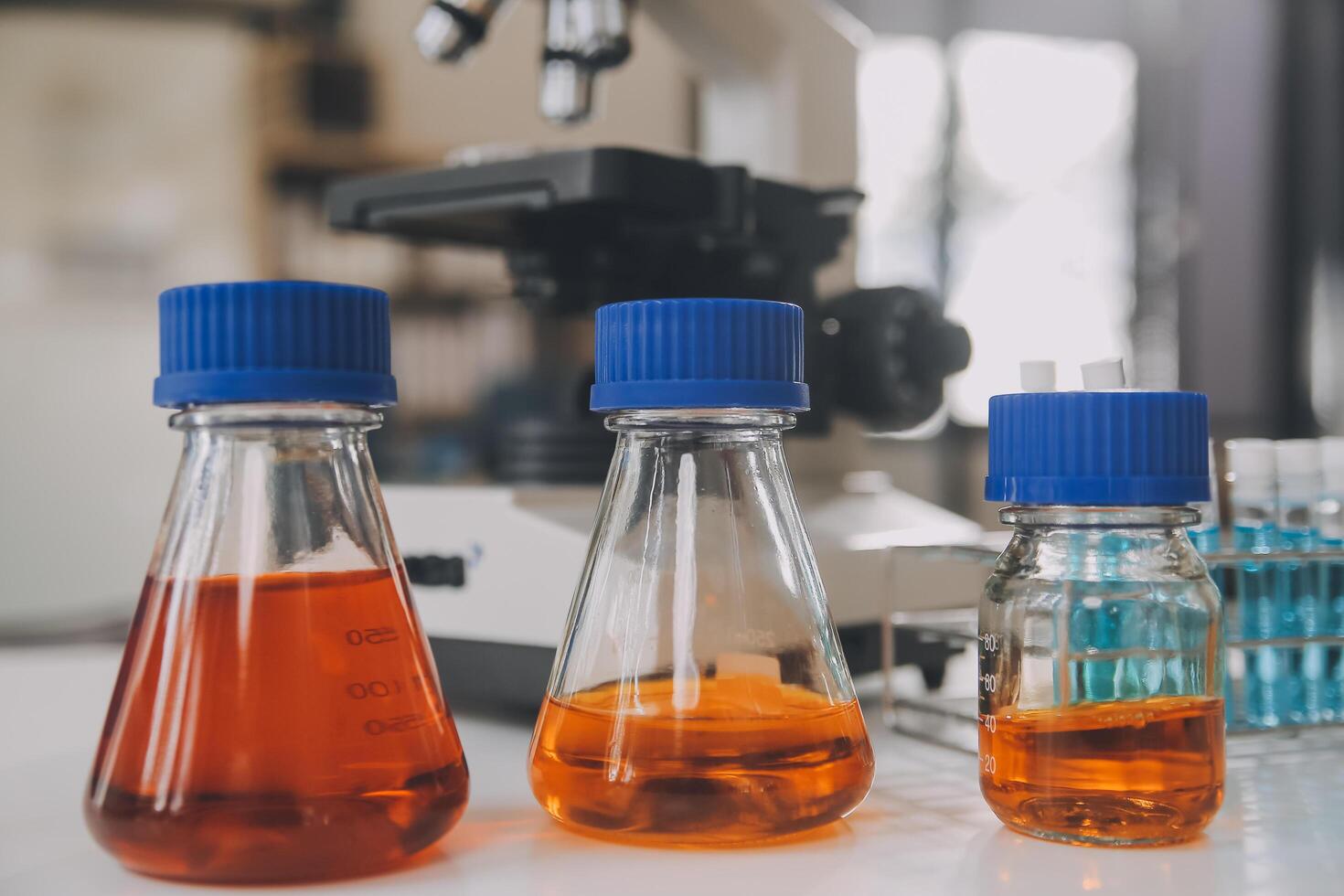 biochemical research scientist team working with microscope for coronavirus vaccine development in pharmaceutical research labolatory, selective focus photo