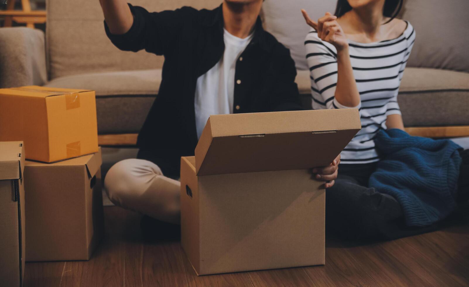 Two Asian blogger showing clothes in front of the camera to recording vlog video live streaming at her shop. Online Shopping Cart notion. on sofa at home photo