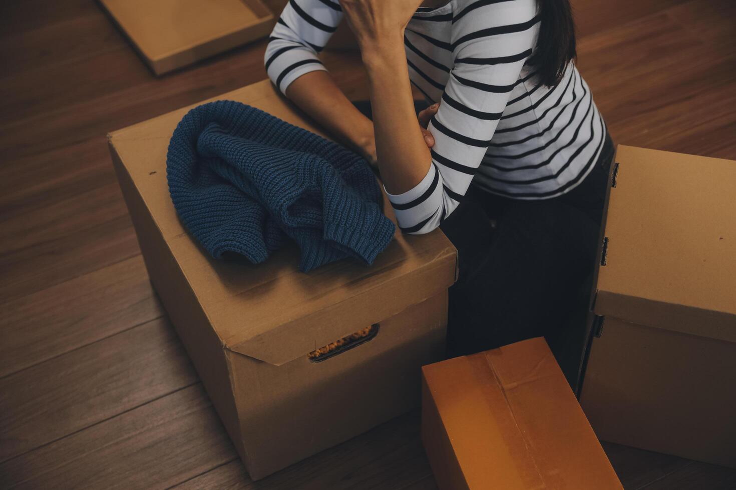 Two Asian blogger showing clothes in front of the camera to recording vlog video live streaming at her shop. Online Shopping Cart notion. on sofa at home photo