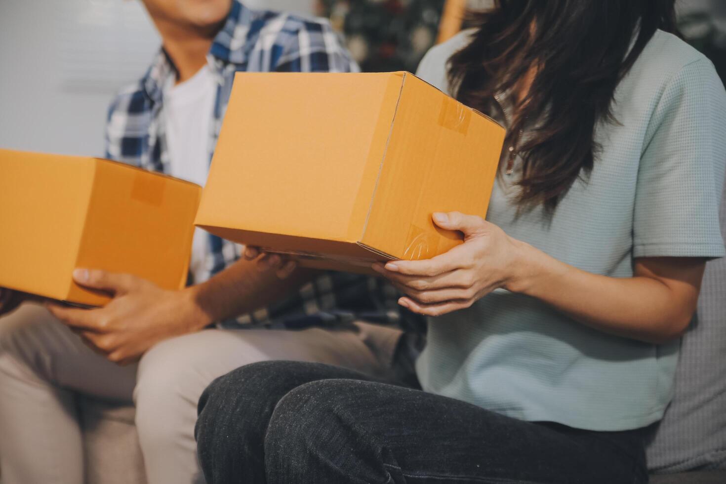 Two Asian blogger showing clothes in front of the camera to recording vlog video live streaming at her shop. Online Shopping Cart notion. on sofa at home photo