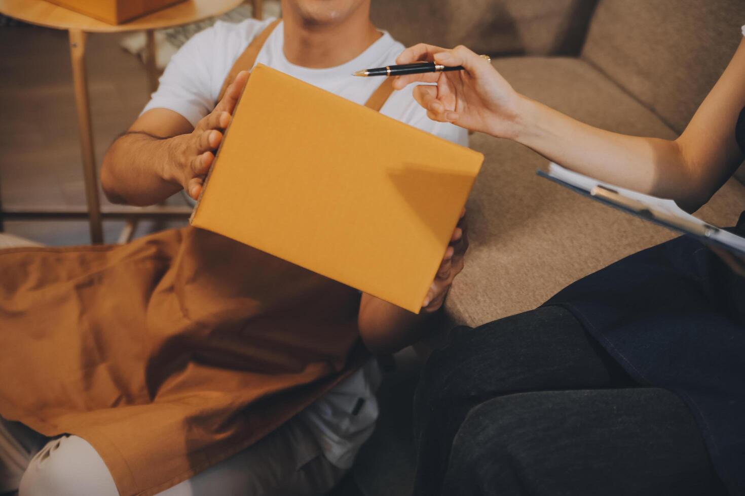 Two Asian blogger showing clothes in front of the camera to recording vlog video live streaming at her shop. Online Shopping Cart notion. on sofa at home photo