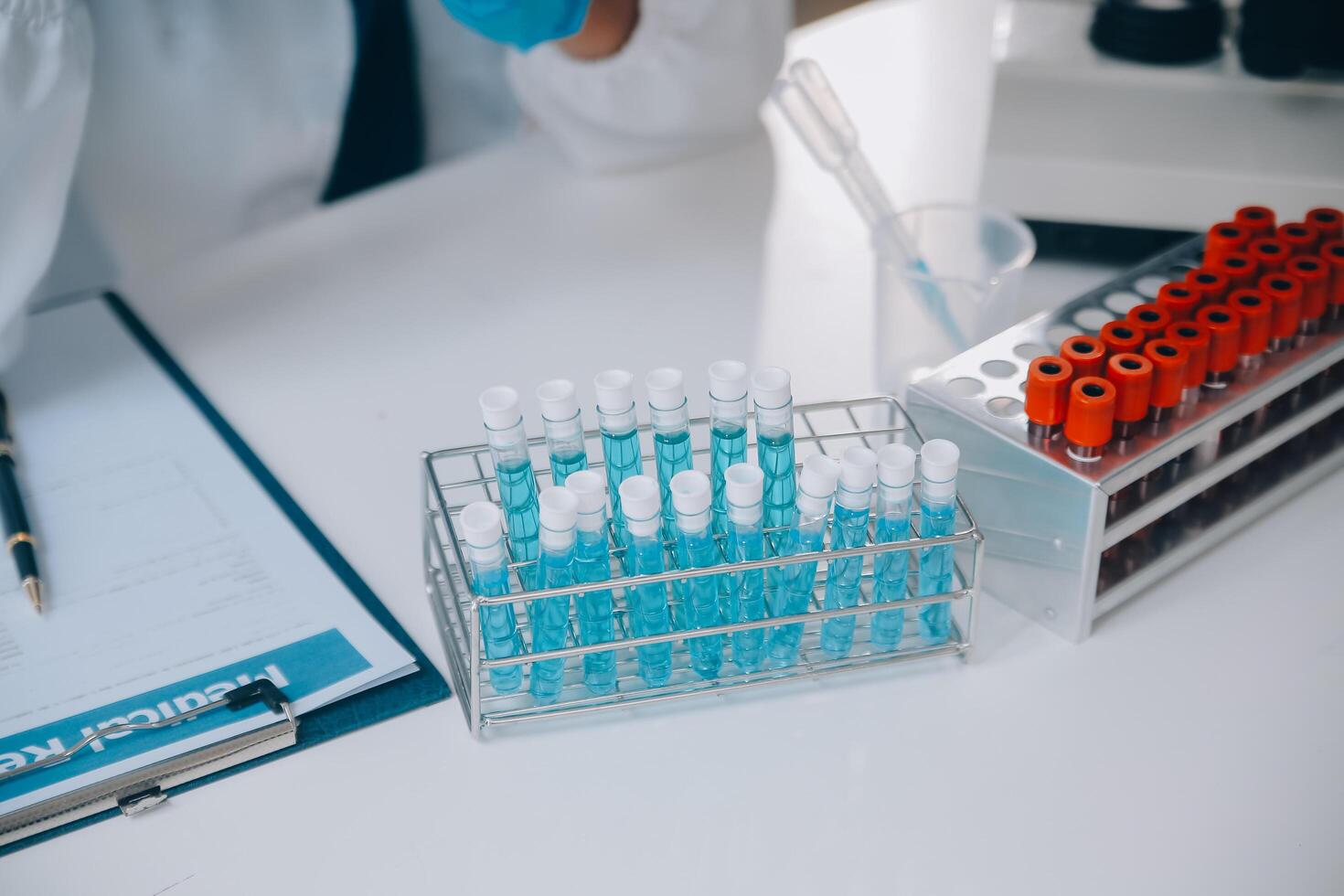 biochemical research scientist team working with microscope for coronavirus vaccine development in pharmaceutical research labolatory, selective focus photo