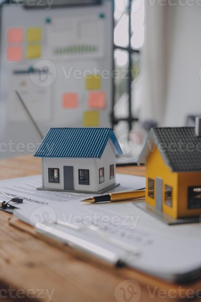 Real estate agent and Sales manager team analysis pricing of rental lease contract of sale purchase agreement, concerning mortgage loan offer for and house insurance. photo