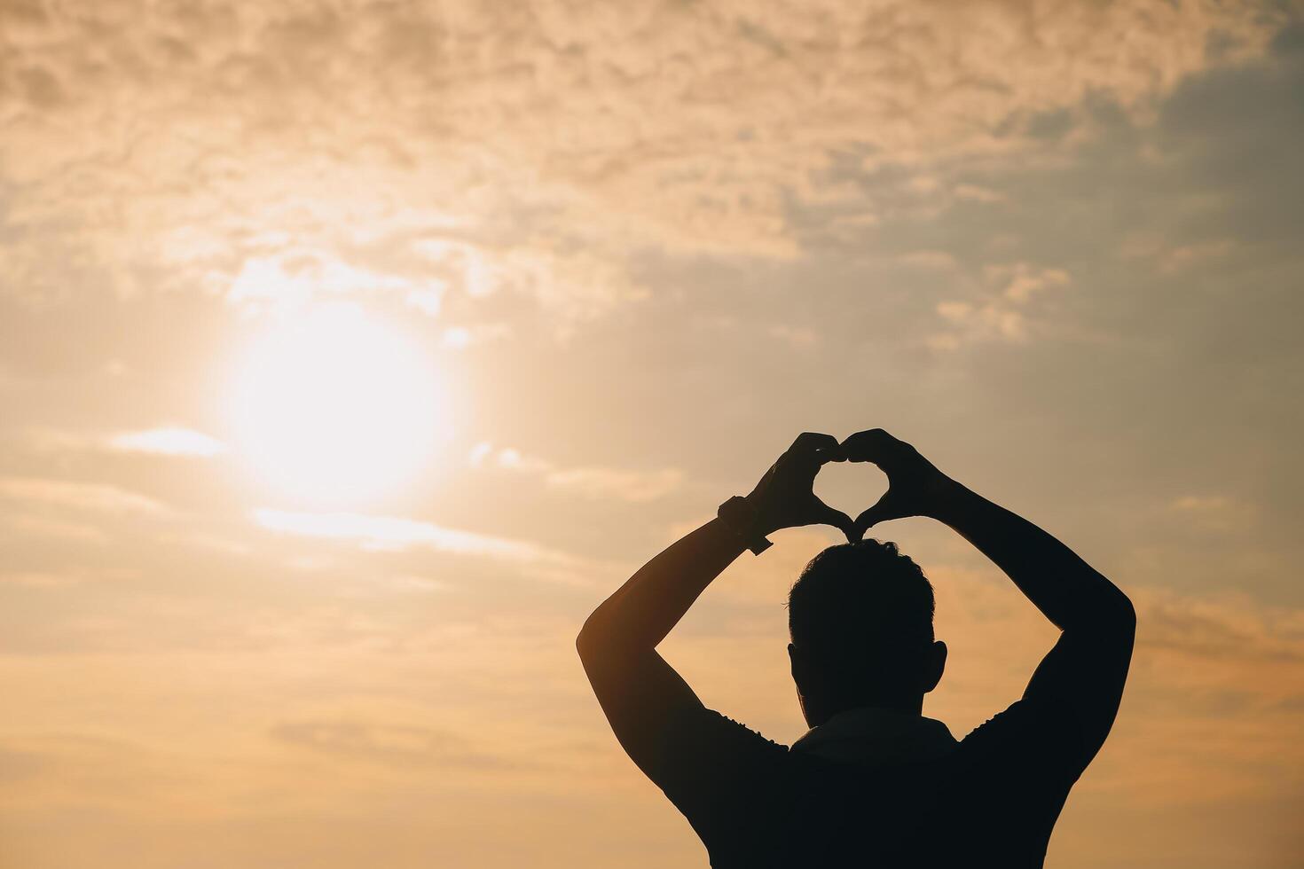 mano corazón marco forma silueta hecho en contra el Dom cielo de un amanecer o puesta de sol en foto