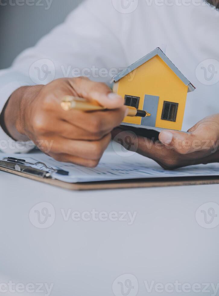 Real estate agent and customer signing contract to buy house, insurance or loan real estate.rent a house,get insurance or loan real estate or property. photo