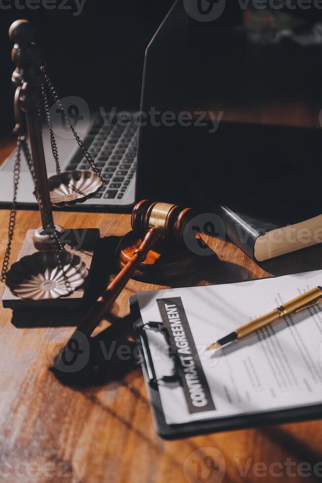 image of judge's hammer, scales lady of justice, law book, laptop computer and contract documents with pen concept of law and justice. photo