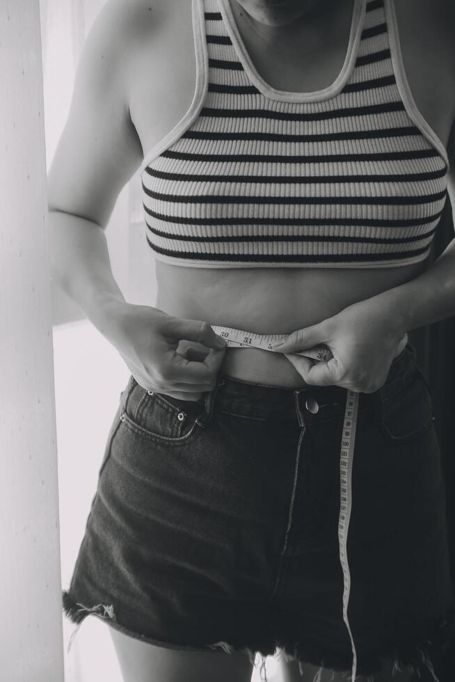 Women body fat belly. Obese woman hand holding excessive belly fat. diet lifestyle concept to reduce belly and shape up healthy stomach muscle. photo