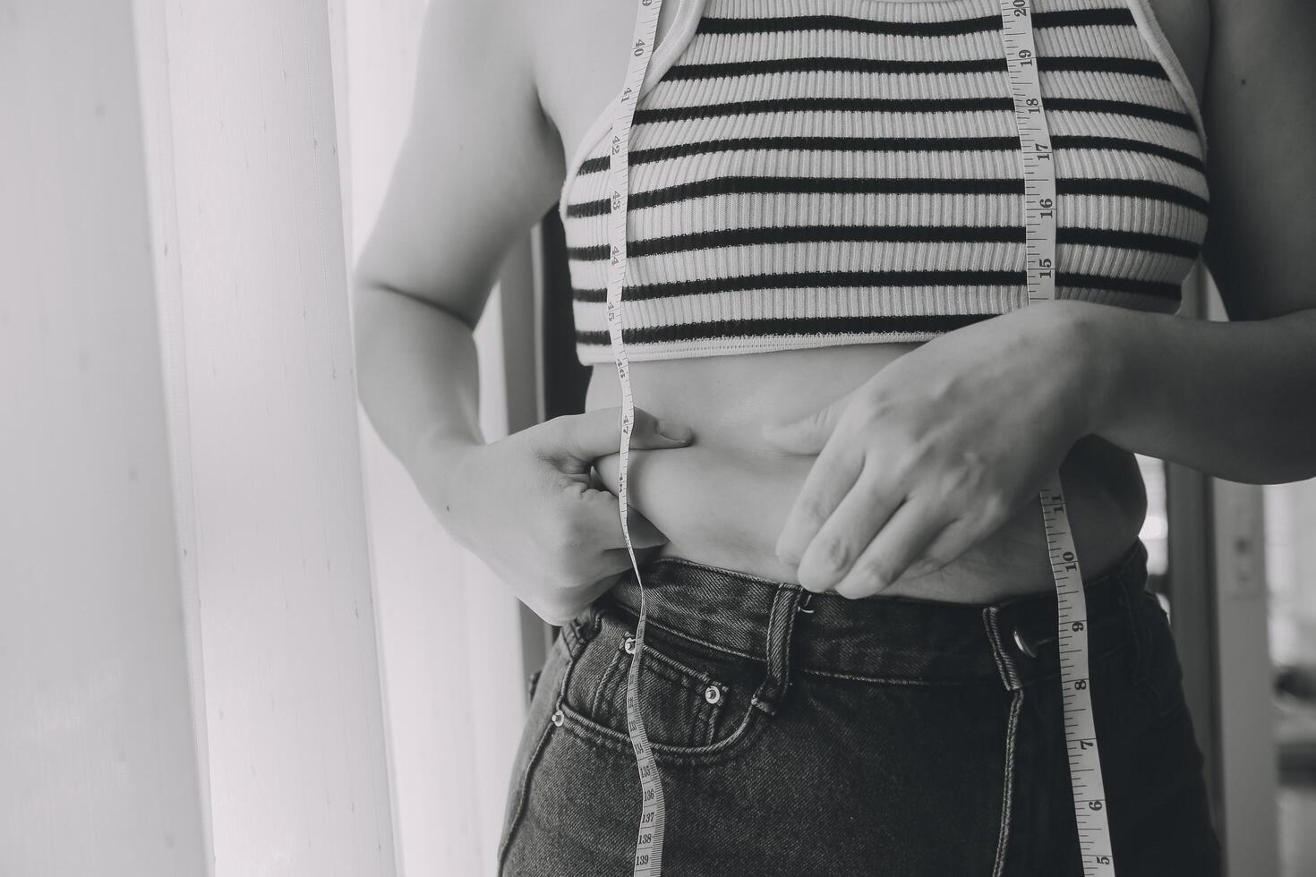 Women body fat belly. Obese woman hand holding excessive belly fat. diet lifestyle concept to reduce belly and shape up healthy stomach muscle. photo