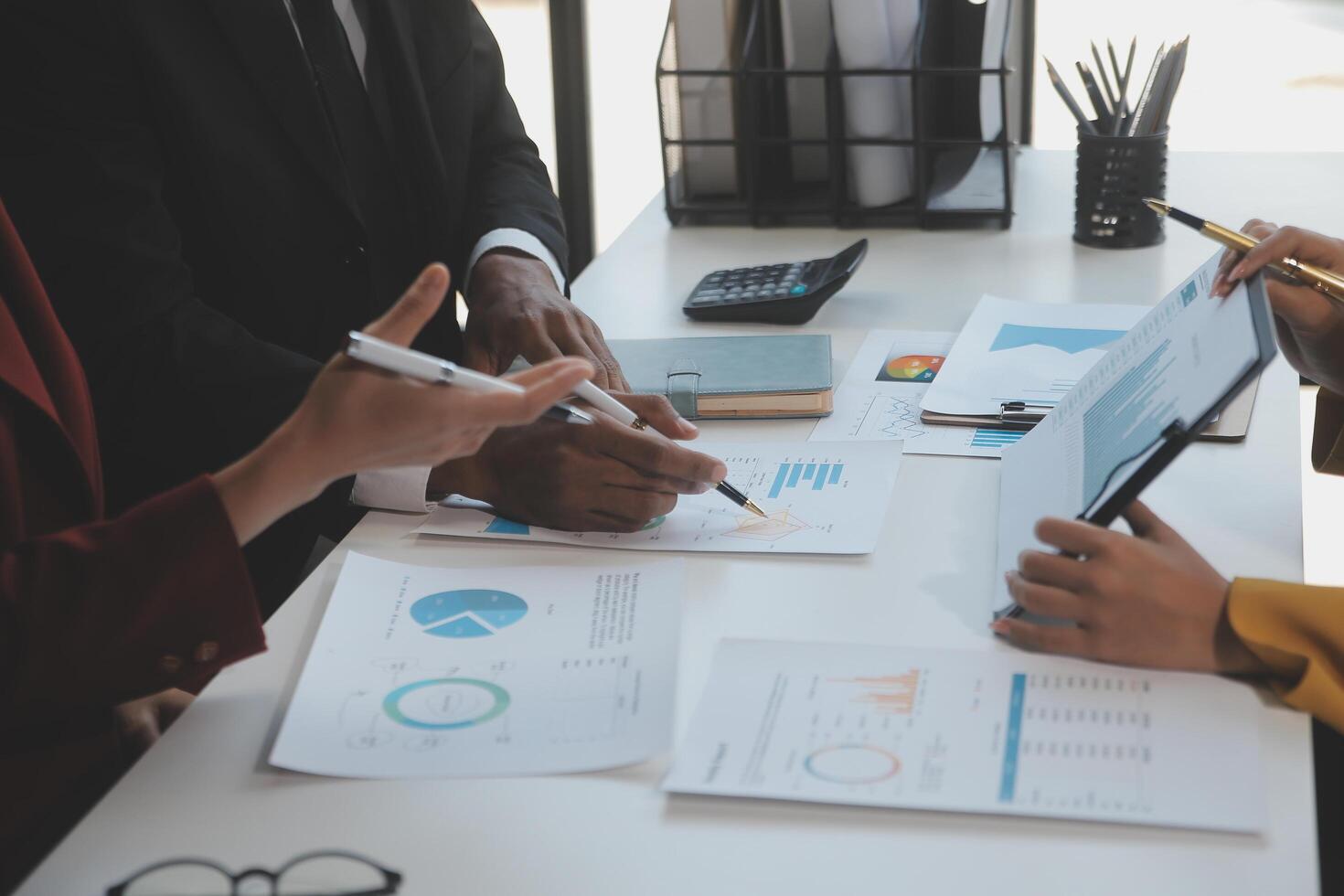 Financial analysts analyze business financial reports on a digital tablet planning investment project during a discussion at a meeting of corporate showing the results of their successful teamwork. photo
