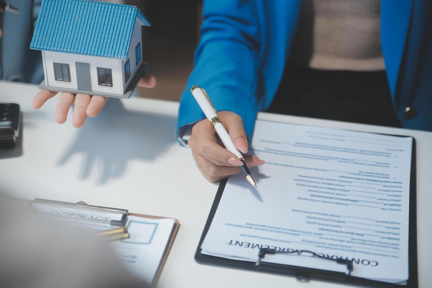 Real estate agent and customer signing contract to buy house, insurance or loan real estate.rent a house,get insurance or loan real estate or property. photo