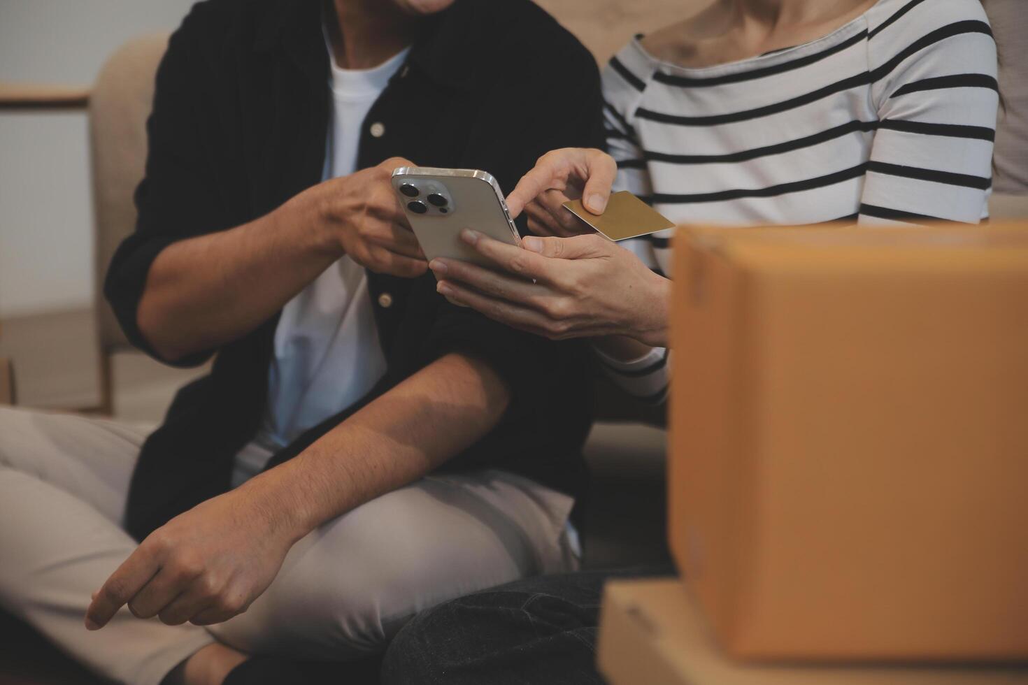 Two Asian blogger showing clothes in front of the camera to recording vlog video live streaming at her shop. Online Shopping Cart notion. on sofa at home photo