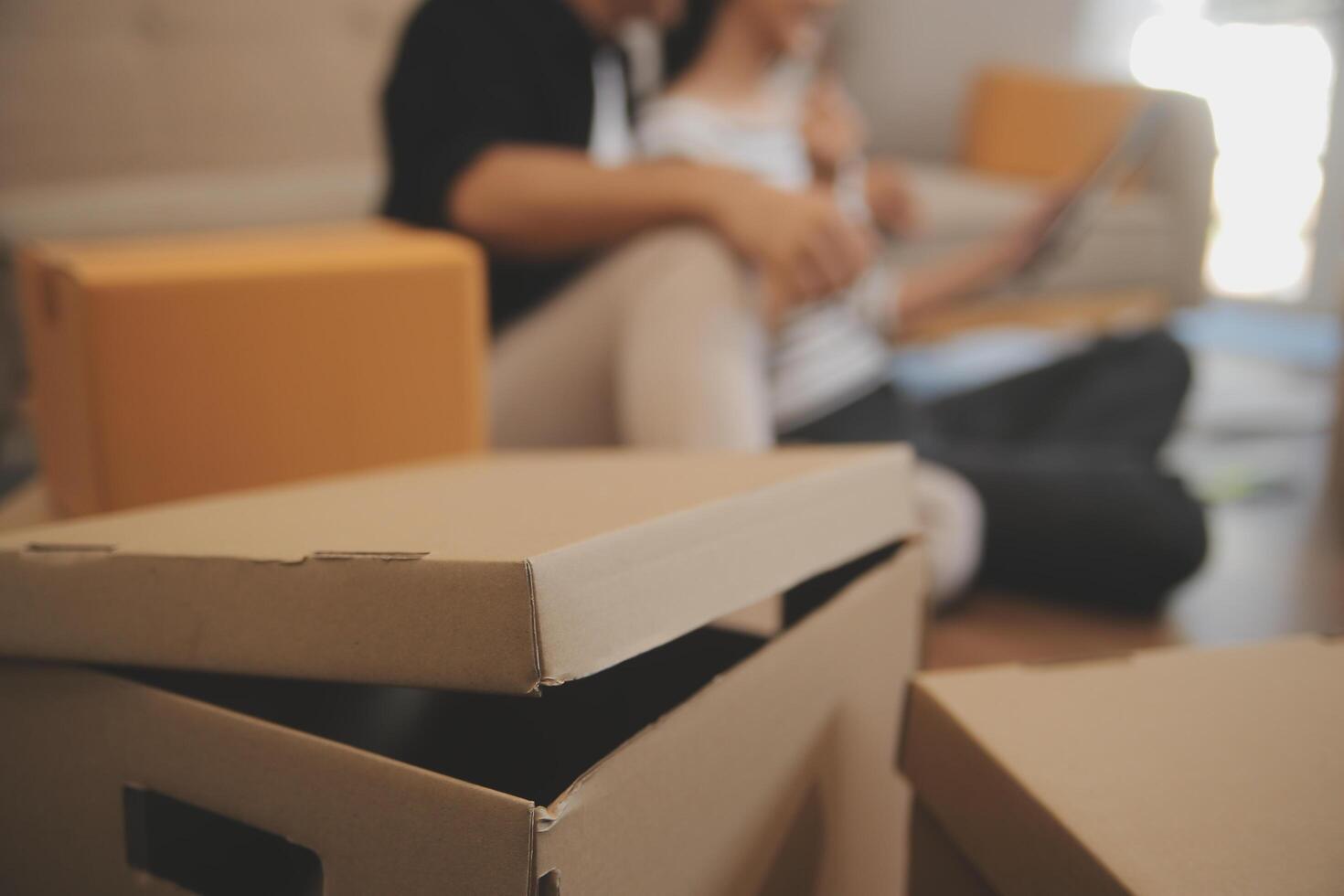 Two Asian blogger showing clothes in front of the camera to recording vlog video live streaming at her shop. Online Shopping Cart notion. on sofa at home photo