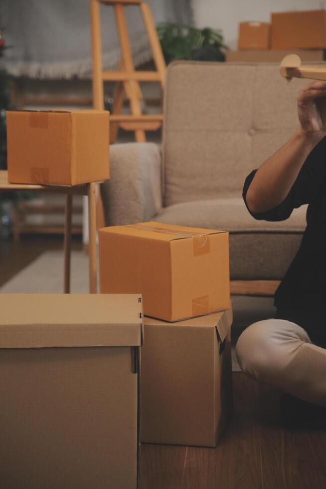 Two Asian blogger showing clothes in front of the camera to recording vlog video live streaming at her shop. Online Shopping Cart notion. on sofa at home photo