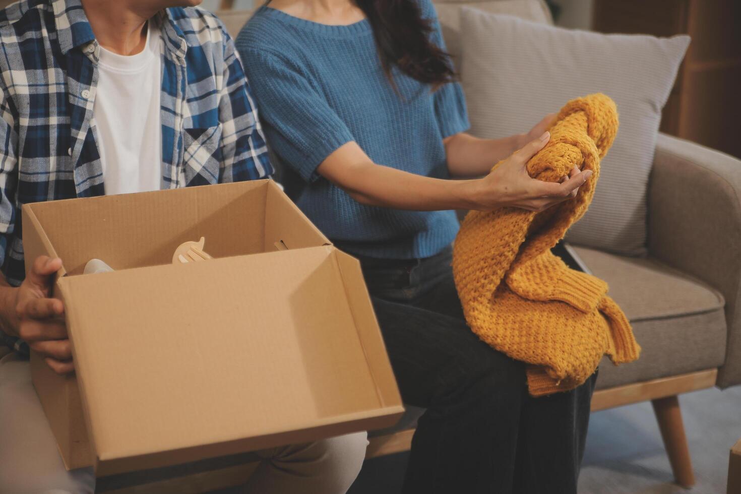 Two Asian blogger showing clothes in front of the camera to recording vlog video live streaming at her shop. Online Shopping Cart notion. on sofa at home photo