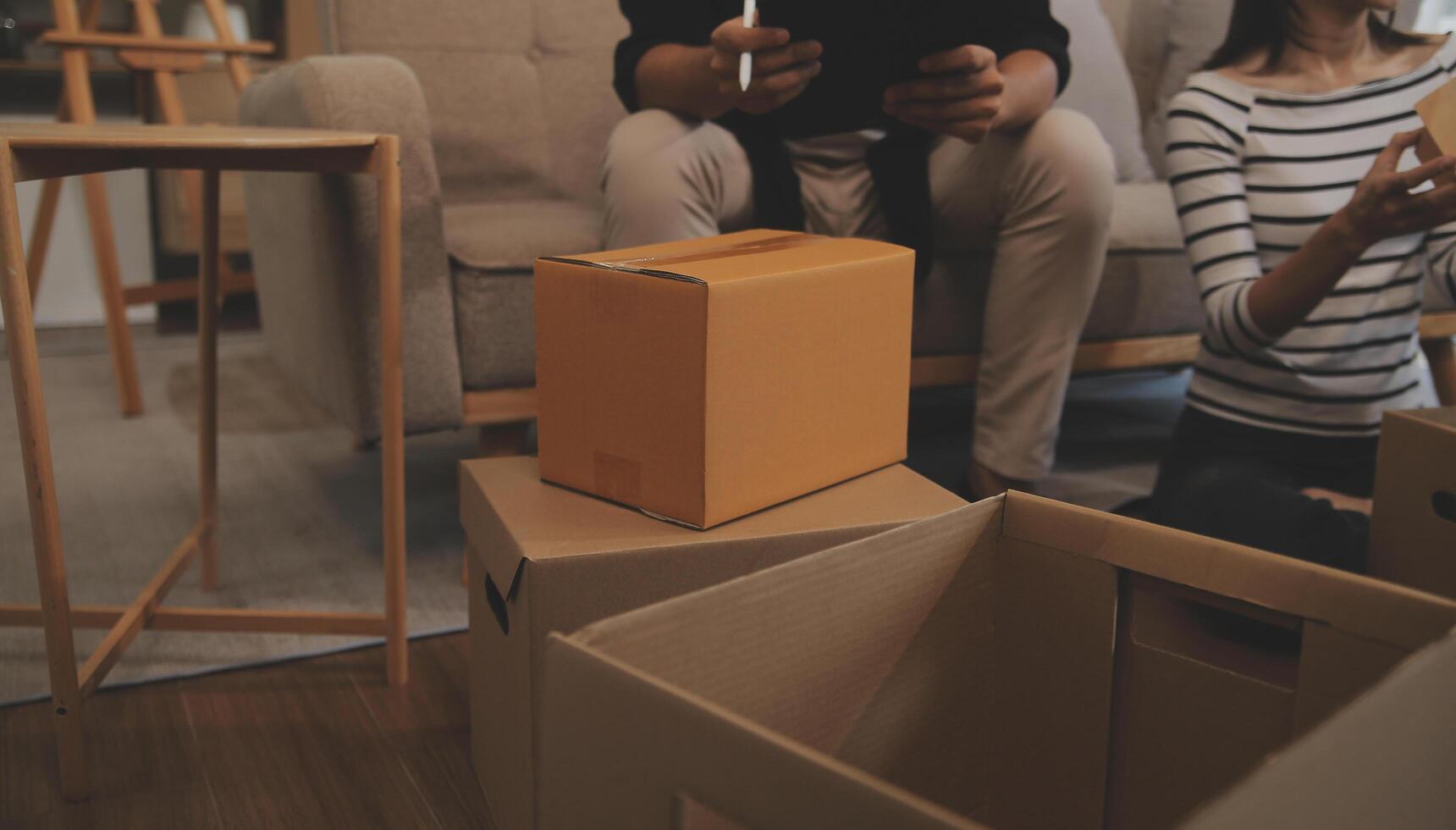 Two Asian blogger showing clothes in front of the camera to recording vlog video live streaming at her shop. Online Shopping Cart notion. on sofa at home photo